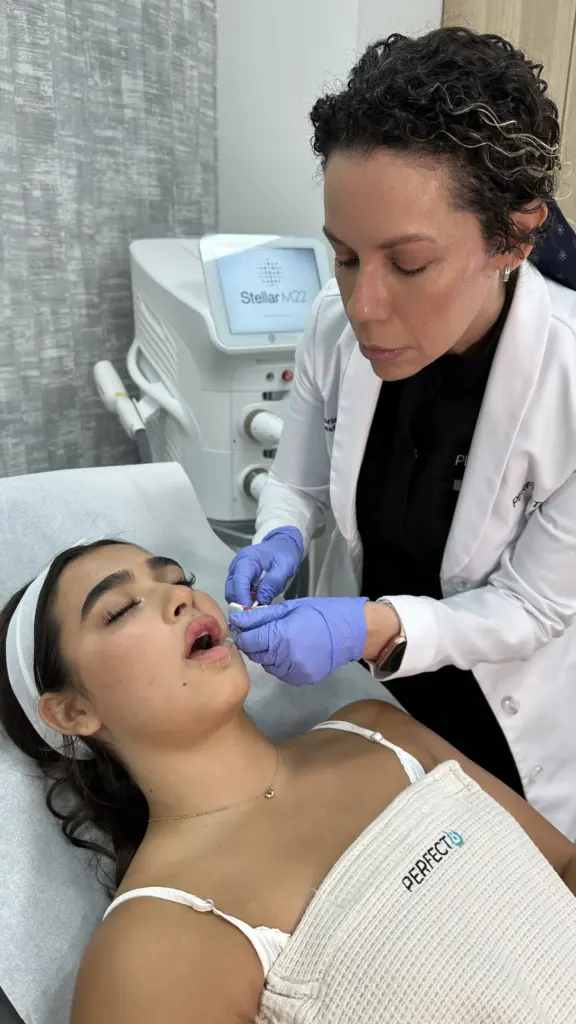 Practitioner injecting dermal lip filler during a lip enhancement procedure at Perfect B in Doral